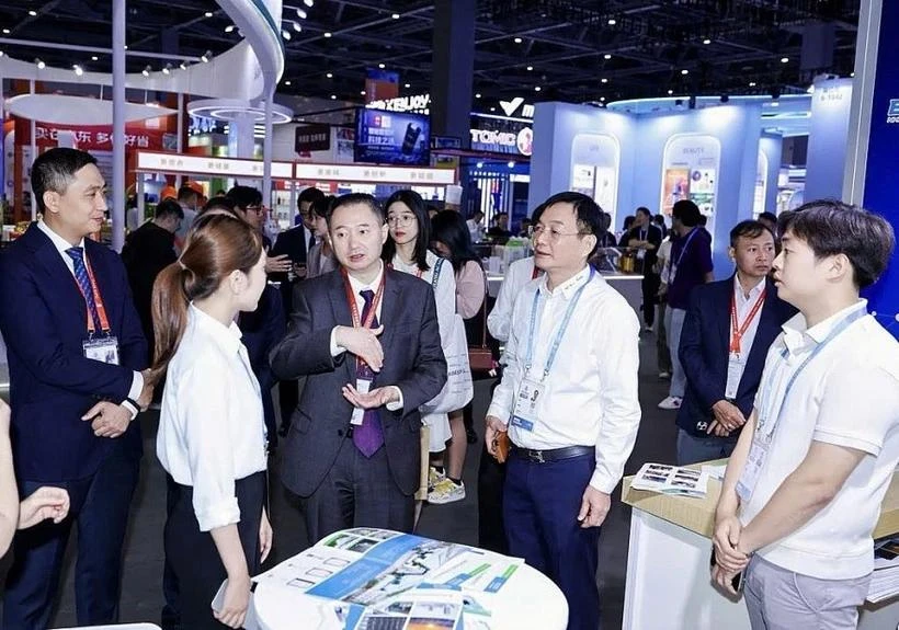 Hoang Minh Chien, subdirector de la Agencia de Promoción Comercial de Vietnam, dependiente del Ministerio de Industria y Comercio, y líderes del Departamento de Comercio de la provincia de Zhejiang, China, visitan los stands de las empresas vietnamitas (Fuente: thoibaotaichinhvietnam.vn) 