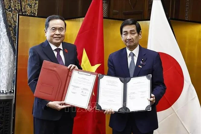 El presidente de la Asamblea Nacional de Vietnam, Tran Thanh Man (izquierda) y el presidente de la Cámara de Consejeros de Japón, intercambian documentos de cooperación (Fuente: VNA) 