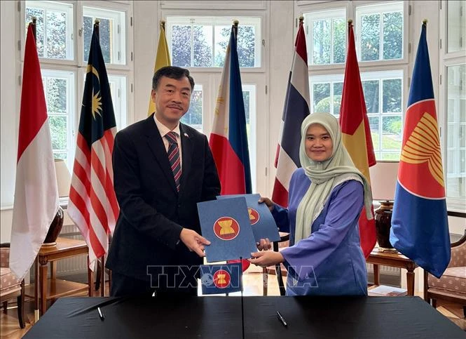 Vietnamese Ambassador to the Czech Republic Duong Hoai Nam receives the rotary chair of the ASEAN Committee in Prague from Malaysian Ambassador Suzilah Mohd Sidek. (Photo: VNA)