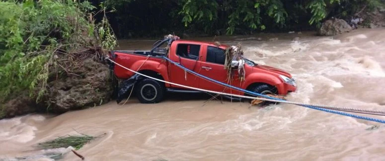 The pickup truck drove through the flooded road, and swept into a swollen roadside creek. (Photo: Cebudailynews)