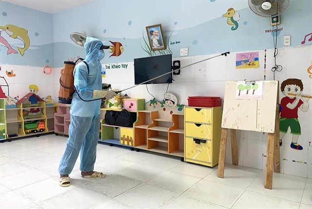 A medical worker sprays disinfectant at a preschool with children suffering from hand-foot-mouth disease in Phu Yen province. (Photo: VNA)