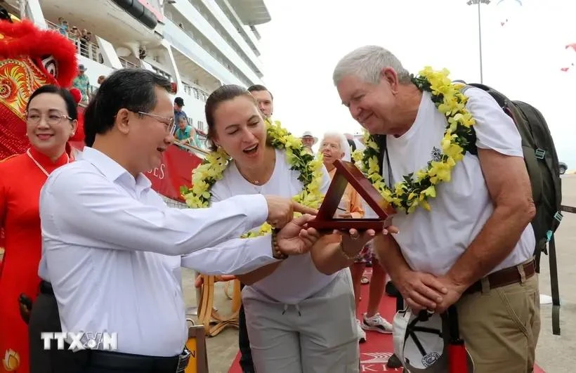 Chairman of the provincial People's Committee Cao Tuong Huy (L) presents a souvenir to David and Tina. (Photo: VNA)