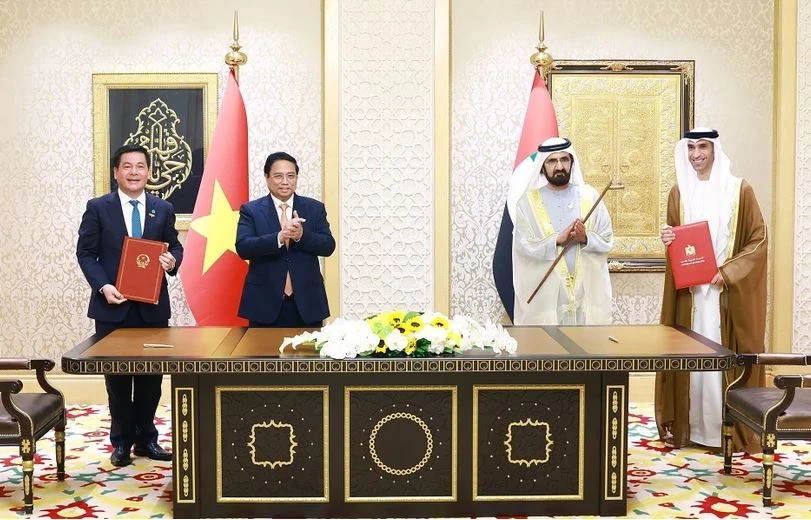 Prime Minister Pham Minh Chinh (second from left) and UAE Vice President and Prime Minister Sheikh Mohammed bin Rashid Al Maktoum (second from right) witness the signing of Comprehensive Economic Partnership Agreement between Vietnam and the United Arab Emirates. (Photo: VNA)