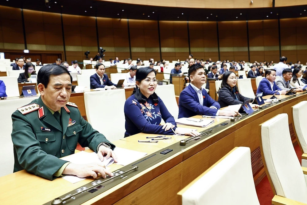 Most of the deputies present at the 15th NA's 8th sitting voting in favour of the law on amending and supplementing several articles of the Law on Officers of the Vietnam People's Army (Photo: VNA)