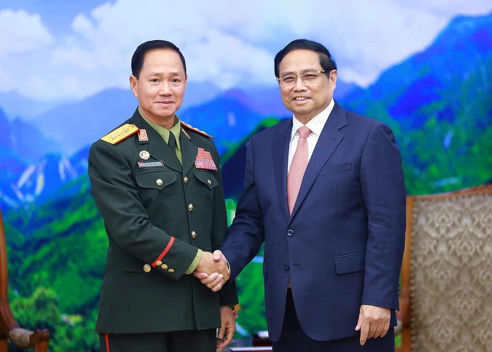 Prime Minister Pham Minh Chinh (R) receives Lao Defence Minister Sen. Lieut. Gen. Khamliang Outhakaysone in Hanoi on December 18. (Photo: VNA)