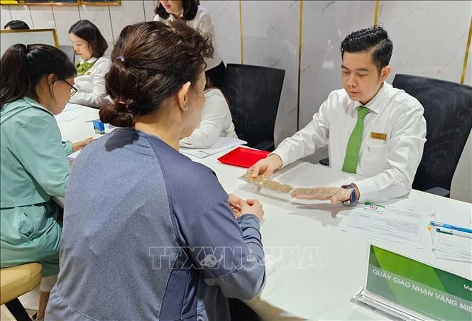 Clientes realizan transacciones en el banco Vietcombank, en Ciudad Ho Chi Minh. (Fuente: VNA)