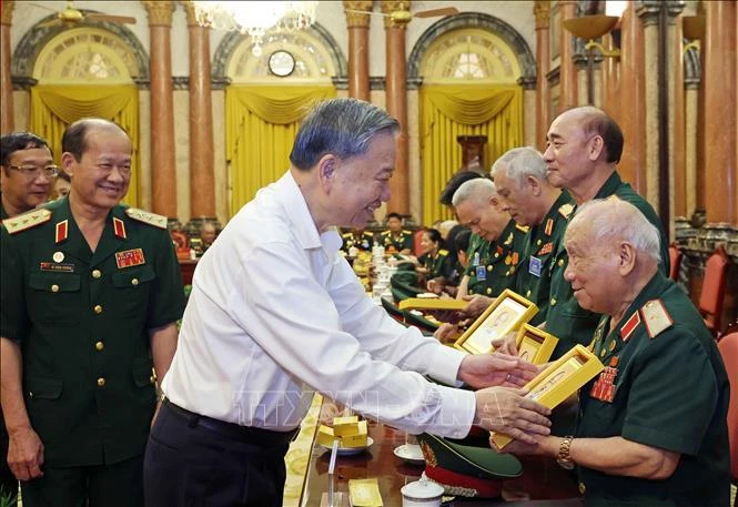  El presidente To Lam entrega una fotografía del Presidente Ho Chi Minh al mayor general Vo So, de 96 años, jefe del Comité de Enlace de Veteranos de la División 305 de Caballería Aérea y Fuerzas Especiales. (Fuente: VNA)