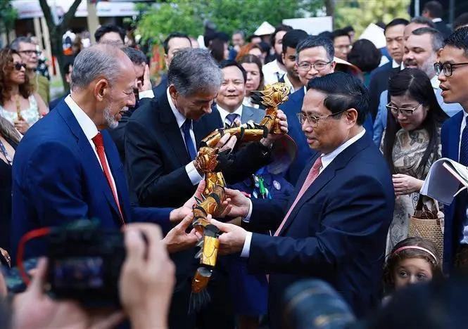 El primer ministro Pham Minh Chinh obsequia marionetas de agua a los delegados. (Foto: VNA)