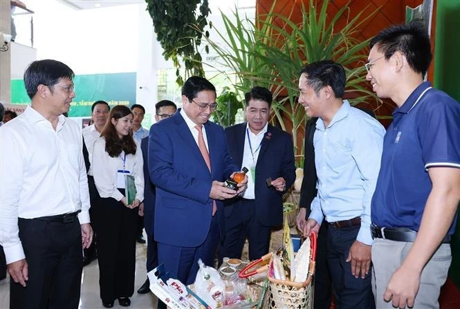 Премьер-министр Фам Минь Тьинь посещает стенд с сельскохозяйственной продукцией провинции Тэйнинь (Фото: ВИA) 