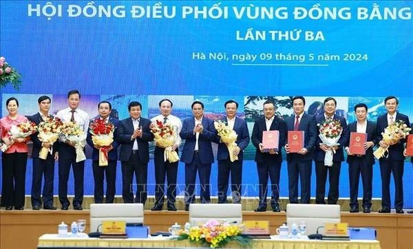 Премьер-министр Фам Минь Тьинь (в центре) вручает руководителям населенных пунктов решения, утверждающие планирование городов и провинций в регионе дельты Красной реки (Фото: ВИА) 