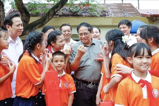 Премьер-министр Фам Минь Тьинь с детьми в ханойском центре по уходу за детьми с ограниченными возможностями 31 мая. (Фото: ВИA)