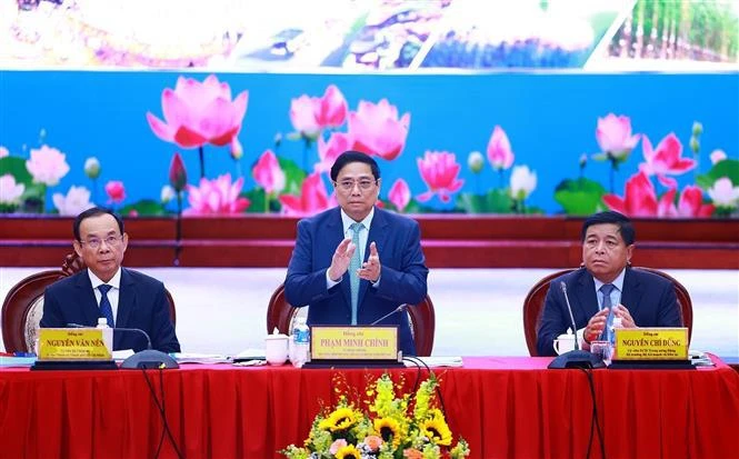 Le Premier ministre Pham Minh Chinh (debout) applaudit en guise de salutation en ouverture de la 3e conférence du Conseil de coordination de la région du Sud-Est. Photo: VNA
