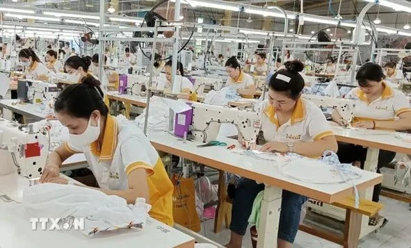 Des ouvriers travaillant dans une chaîne de confection de vêtements pour l'exportation. Photo: VNA