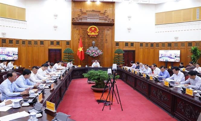 Le Premier ministre Pham Minh Chinh (centre) lors de la réunion, à Hanoi, le 23 mai. Photo : VNA