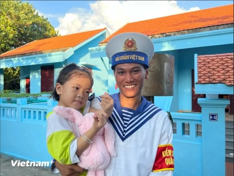 Un soldat de Truong Sa prend dans ses bras une petite fille sur l'île de Truong Sa. Photo: VietnamPlus