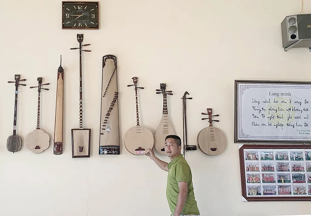 Des instruments de musique folklorique fabriqués par le regretté artisan émérite Dao Van Soan sont exposés à la maison communale du village. Photo : nhipsonghanoi.hanoimoi.vn