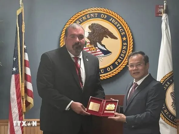 Le vice-ministre de la Sécurité publique Nguyên Van Long remet un souvenir au directeur adjoint par intérim de la Division des programmes correctionnels du Bureau fédéral américain des prisons, Shane Salem. Photo : VNA