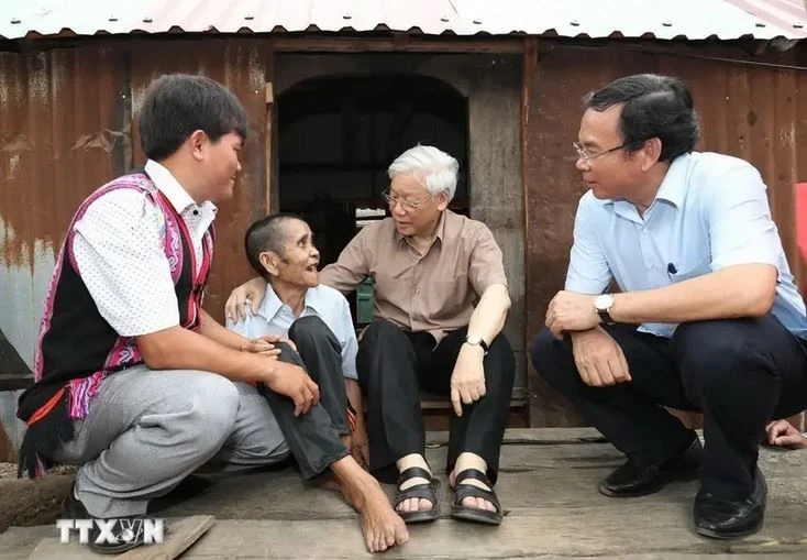 Le secrétaire général Nguyên Phu Trong (2e à partir de la droite) rend visite à la famille de l’invalide de guerre Dinh Phi, une famille bénéficiaire bénéficiaires de politiques sociales, dans le village de Tung Ke 2, commune d’Ayun, district de Chu Sê, province de Gia Lai, le 12 avril 2017. Photo : VNA