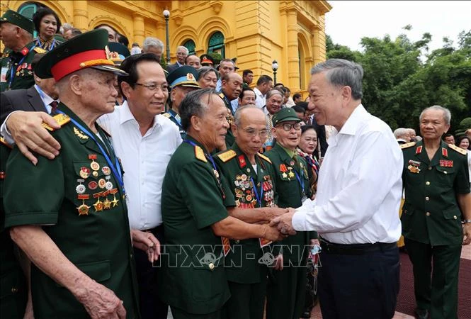 Le président Tô Lâm avec la délégation des personnes ayant rendu des services méritoires à la révolution, à Hanoi, le 22 juillet. Photo: VNA