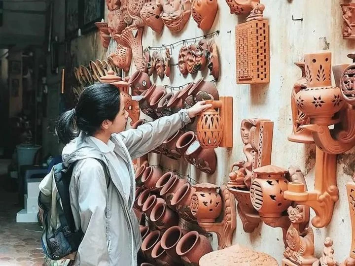 Une touriste visitant le village de potterie de Bat Tràng, à Hanoi. Photo: baoangiang.com.vn