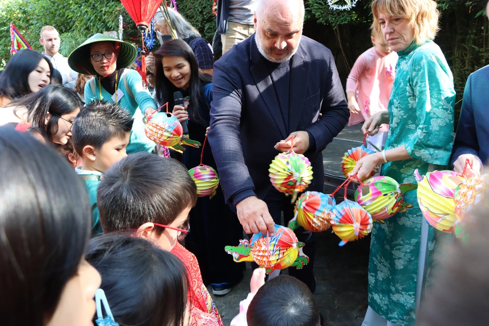  Audrey Lhoest, première échevine, et Christos Doulkeridis, bourgmestre de la commune d'Ixelles, offrent des lanternes aux enfants participant à la fête. Photo : VNA