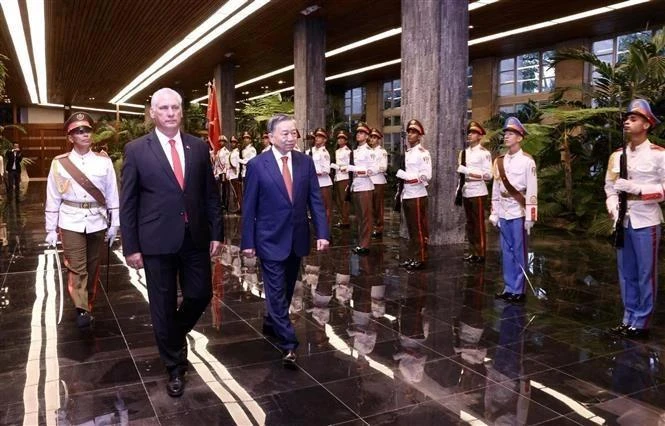 Le premier secrétaire du Parti communiste cubain (PCC) et président cubain Miguel Díaz-Canel Bermúdez et le secrétaire général du Parti communiste du Vietnam et président vietnamien Tô Lâm (à droite) passent en revue la garde d’honneur. Photo: VNA