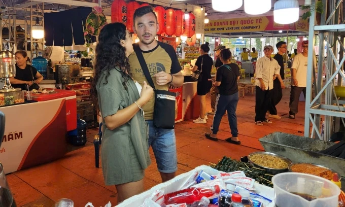 Maria et son petit ami cherchent des plats vietnamiens lors du festival le soir du 23 octobre. Photo: CPV