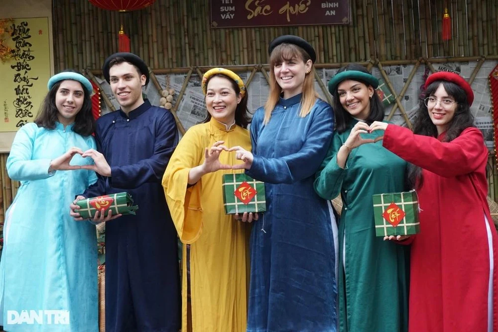 Les étudiants internationaux de l'Université du commerce extérieur de Hanoï en Ao dai (robe traditionnelle vietnamienne). Photo: Dantri 