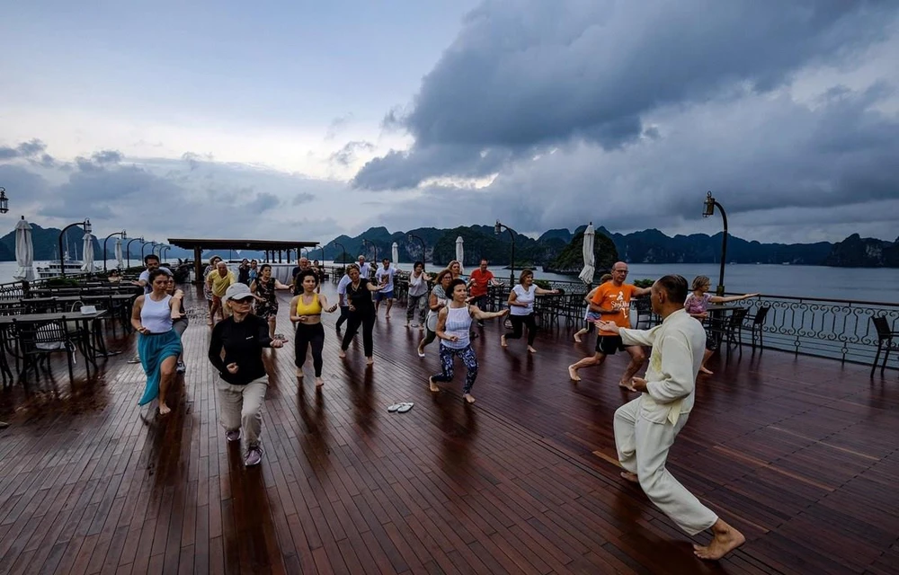 International tourists practice Tai chi aboard their cruise visiting Ha Long Bay. (Photo: VietnamPlus) 