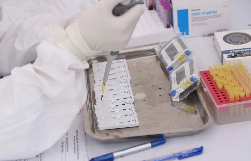 A health worker performs rapid tests for SARS-CoV-2 in a facility in Yen Hoa, Cau Giay, Hanoi on April 3. (Photo: VNA)