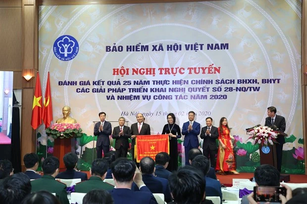 Prime Minister Nguyen Xuan Phuc presents emulation flag tothe Vietnam Social Security with the Government. (Photo: VietnamPlus)