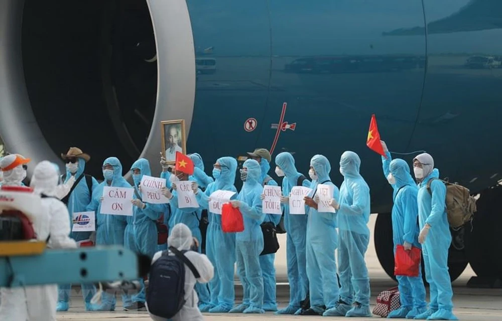 Returnees show their gratitude toward the Party and State for assistance during the hard time of the COVID-19 pandemic (Photo: VNA).