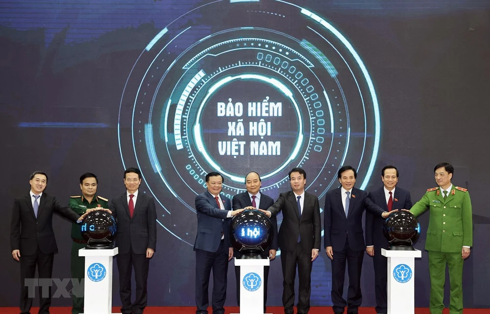 Prime Minister Nguyen Xuan Phuc and other delegates press the button to launch the “VssID - Digital Social Insurance” application (Photo: VNA)