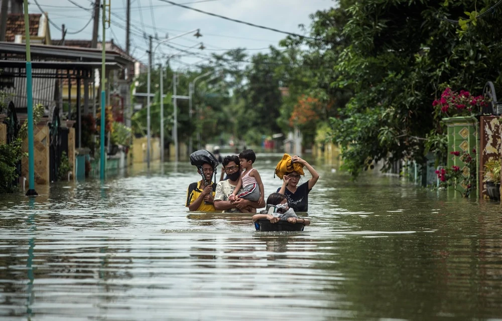 Residents evacuate their flooded homes in Gresik, East Java, Indonesia on December 15, 2020, as the rainy season brings floods to many areas in Jakarta and Java. (Photo: AFP/VNA)