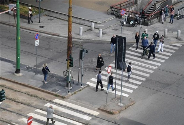 People cross a street in Milan city of Italy (Photo: Xinhua/VNA)