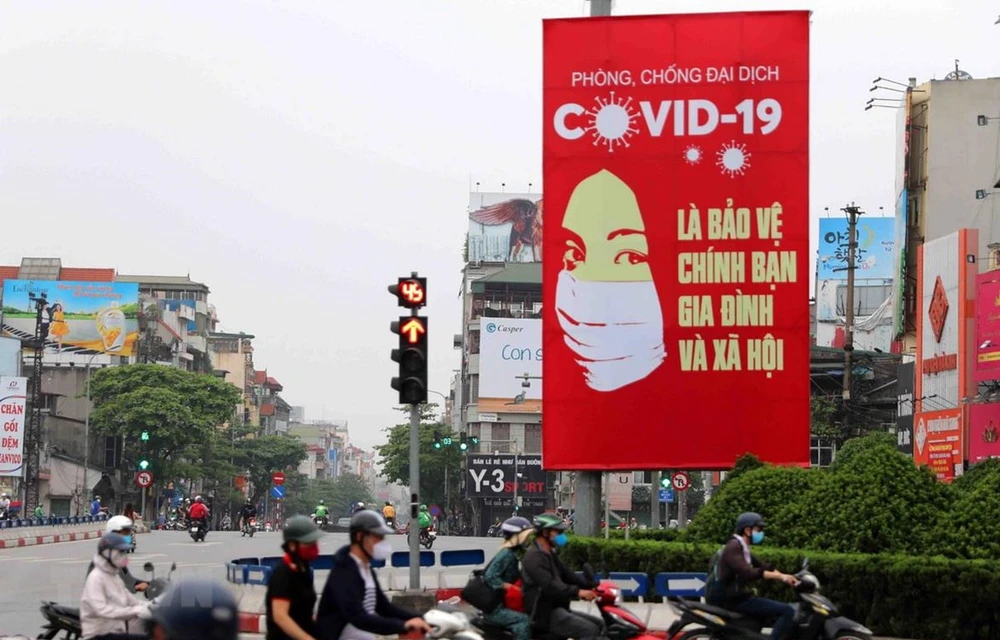 Рекламный щит о борьбе против эпидемии в ханойском перекрестке. (Фото: Тхань Тунг/ВИА)