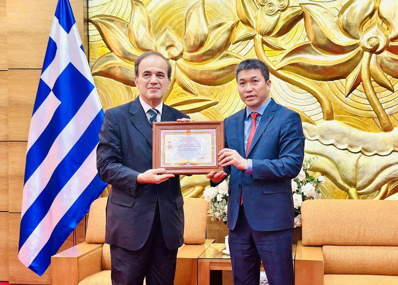 President of the Vietnam Union of Friendship Organisations Phan Anh Son (right) presents the honour to Greek Ambassador to Vietnam Georgios Stilianopoulos at the ceremony in Hanoi on October 15. (Photo: VNA) 