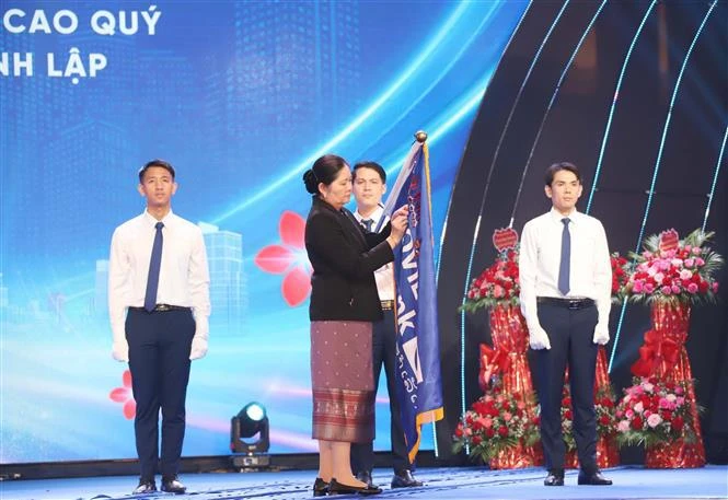 Acting Governor of the Bank of the Lao PDR Vathana Dalaloy, on behalf of the Lao state, presents first-class Labour Order to LaoVietBank (Photo: VNA)