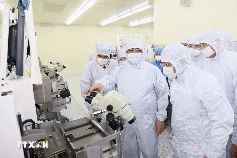 PM Pham Minh Chinh visits a semiconductor assembling line at Hana Micro Vina (Photo: VNA)