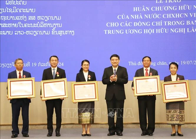 Chairman of the Vietnam-Laos Friendship Association (VLFA) Central Committee Nguyen Dac Vinh (third, right) presents the Friendship Order to 15 members of the Laos-Vietnam Friendship Association (LVFA) Central Committee (Photo: VNA)