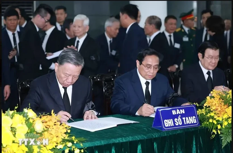 Politburo member and State President To Lam (left), and Politburo member and Prime Minister Pham Minh Chinh (centre) write in the book of condolences. (Photo: VNA)