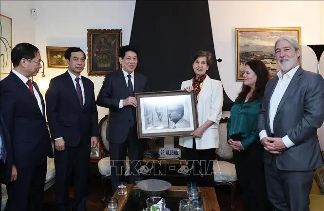 President Luong Cuong (third, left) presents a photo to Senator Isabel Allende, a daughter of the late Chilean President (Photo: VNA)