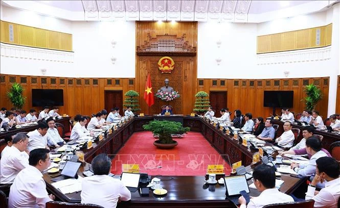 Prime Minister chairs a meeting between permanent Cabinet members and representatives of ministries and agencies on inflation control on June 8. (Photo: VNA)