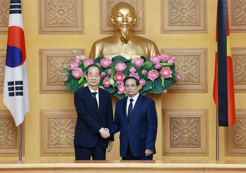 Prime Minister Pham Minh Chinh (R) hosts a reception for his Korean counterpart Han Duck Soo. (Photo: VNA)