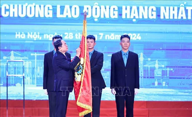 越南国会主席陈青敏将一等劳动勋章别在越南劳动总联合会传统旗帜上。图自越通社
